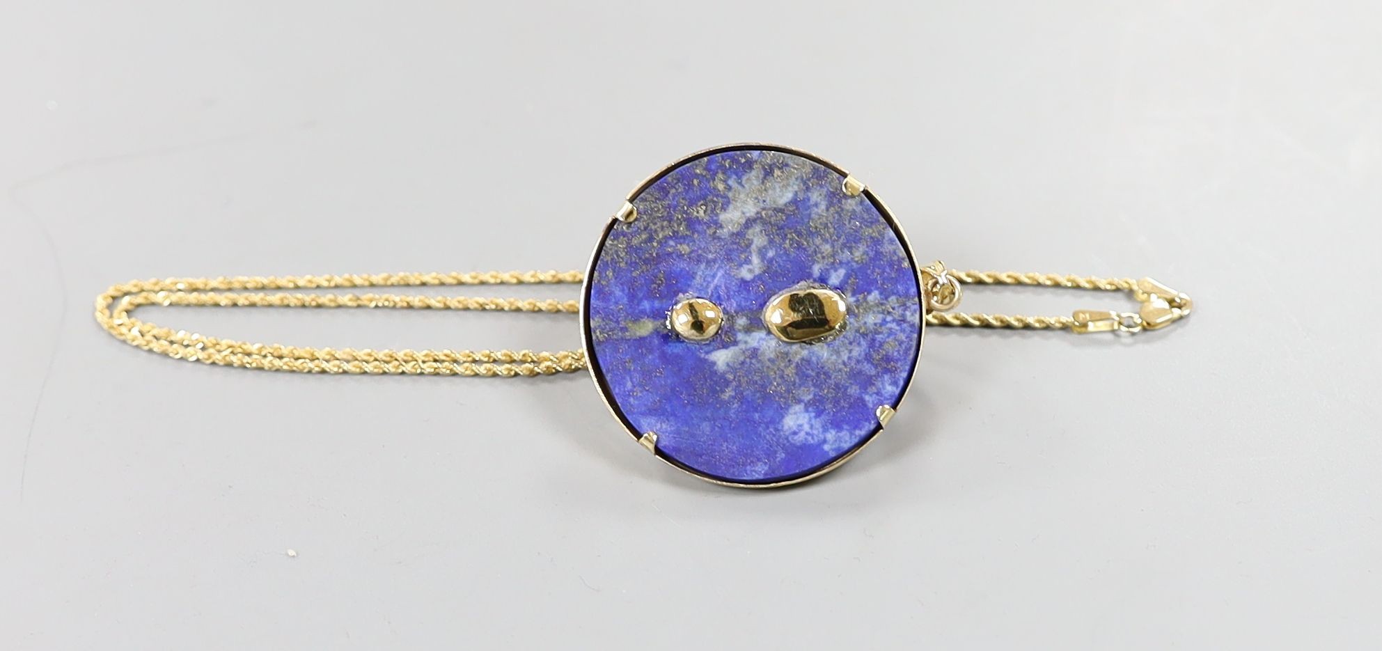 An Egyptian yellow metal earring from the Josephine Dubois Collection, now mounted on a 14l and lapis lazuli circular pendant, with a 14k chain